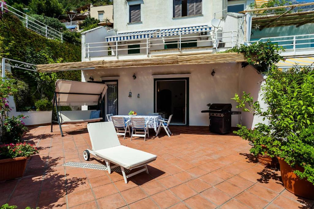 eine Terrasse mit einem Tisch und Stühlen vor einem Haus in der Unterkunft Casa Dorothea 1 in Positano