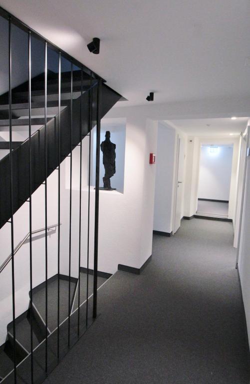 a room with a staircase with a statue on the wall at Hotel & Restaurant Forni in Airolo