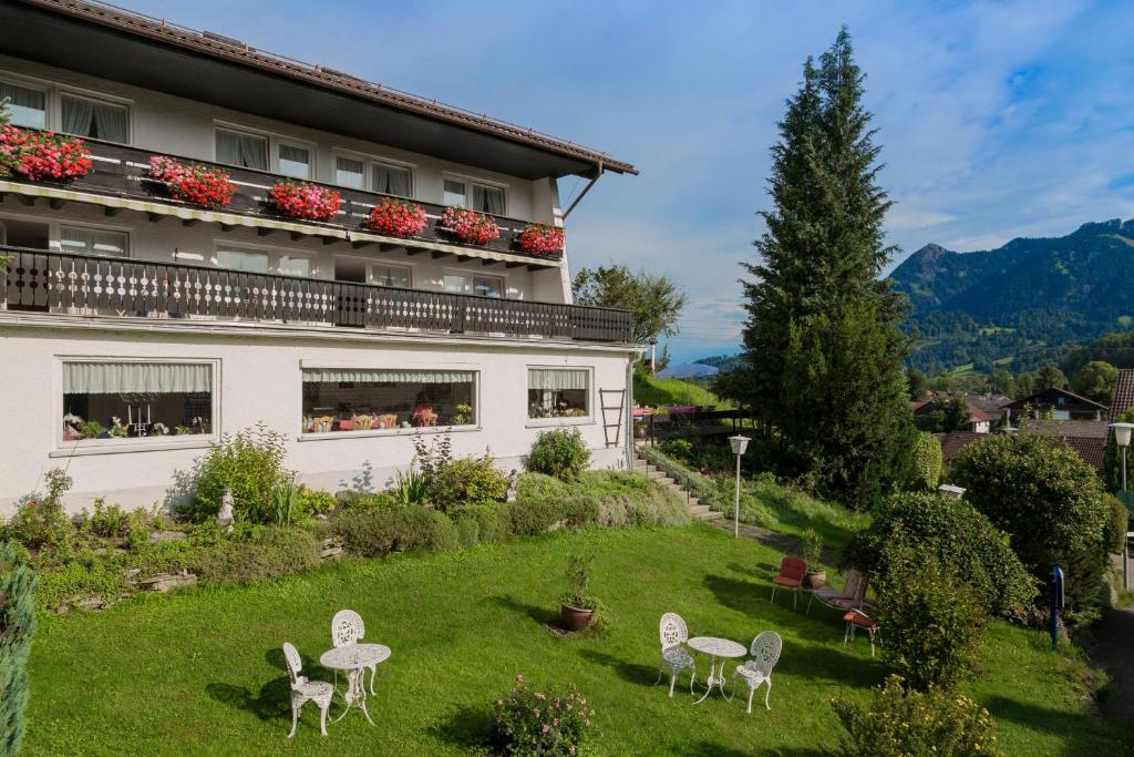 a building with chairs in the yard of a building at Hotel-Pension Johanna in Sonthofen