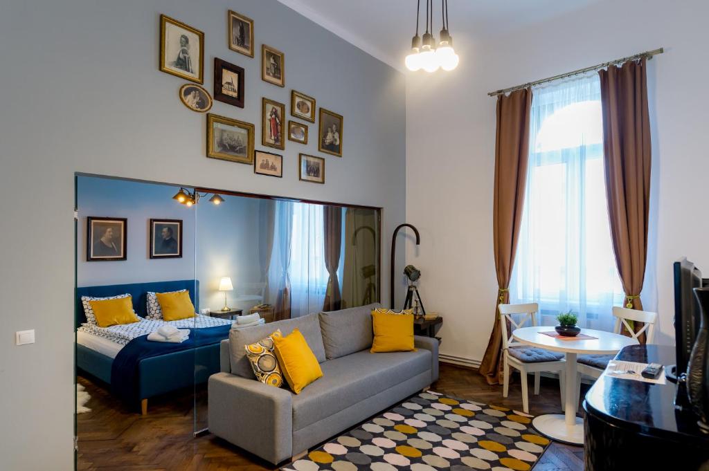 Cluj Aparthotel في كلوي نابوكا: غرفة معيشة مع أريكة وطاولة