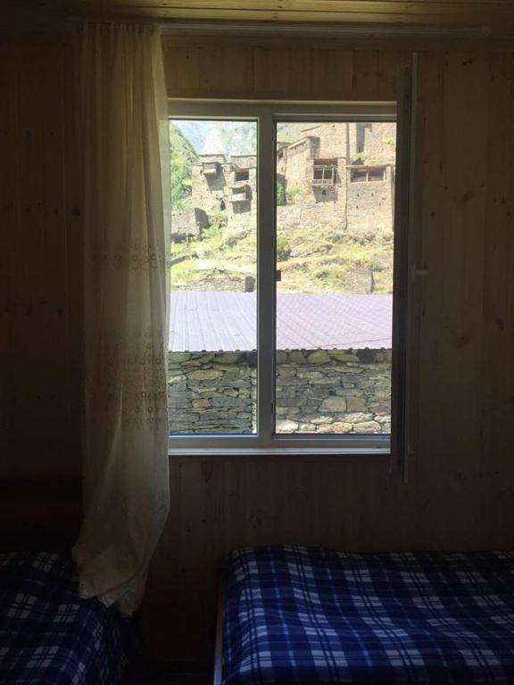 a bedroom with a window and a bed in front of it at Shatili ( Green House ) in Shatili