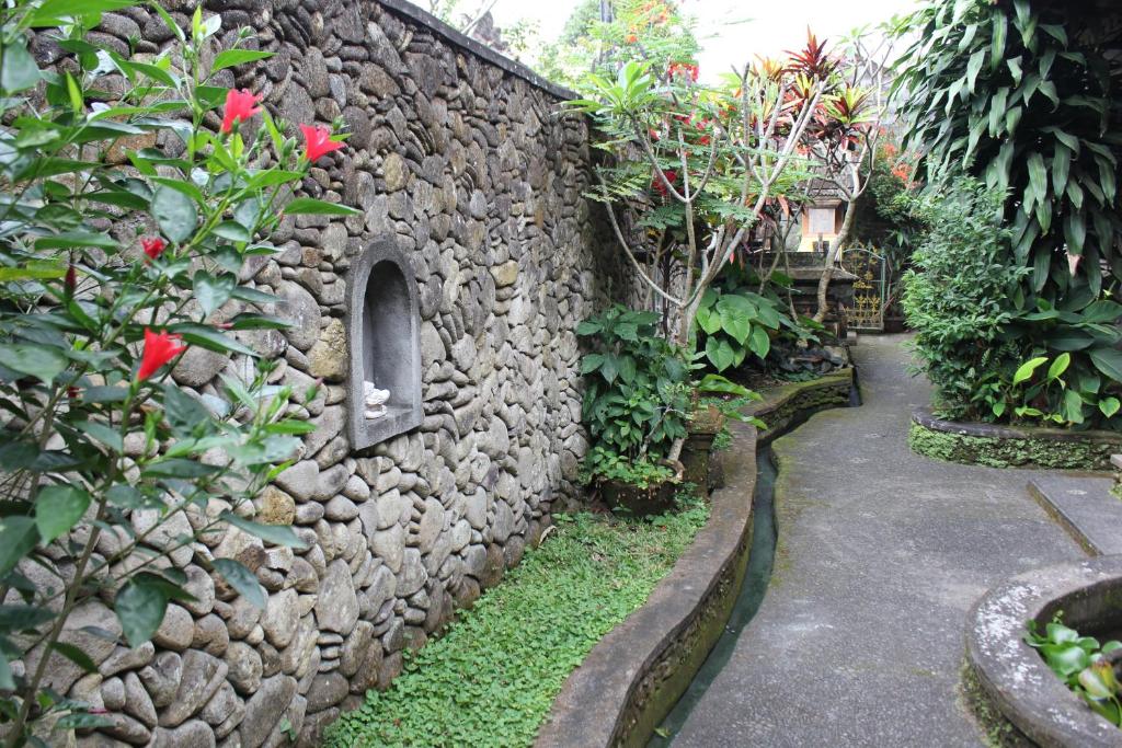 eine Steinmauer mit einem Gehweg im Garten in der Unterkunft Pondok Kecil Bungalow in Ubud