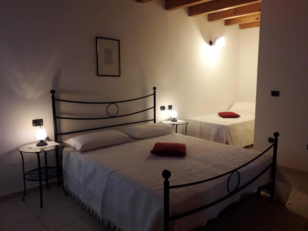 - une chambre avec un grand lit et 2 tables dans l'établissement LA TANA DEL PICCHIO, à Neviano degli Arduini