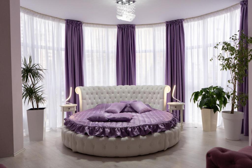 a bedroom with a large bed with purple pillows at Garni Hotel Lotos in Niš