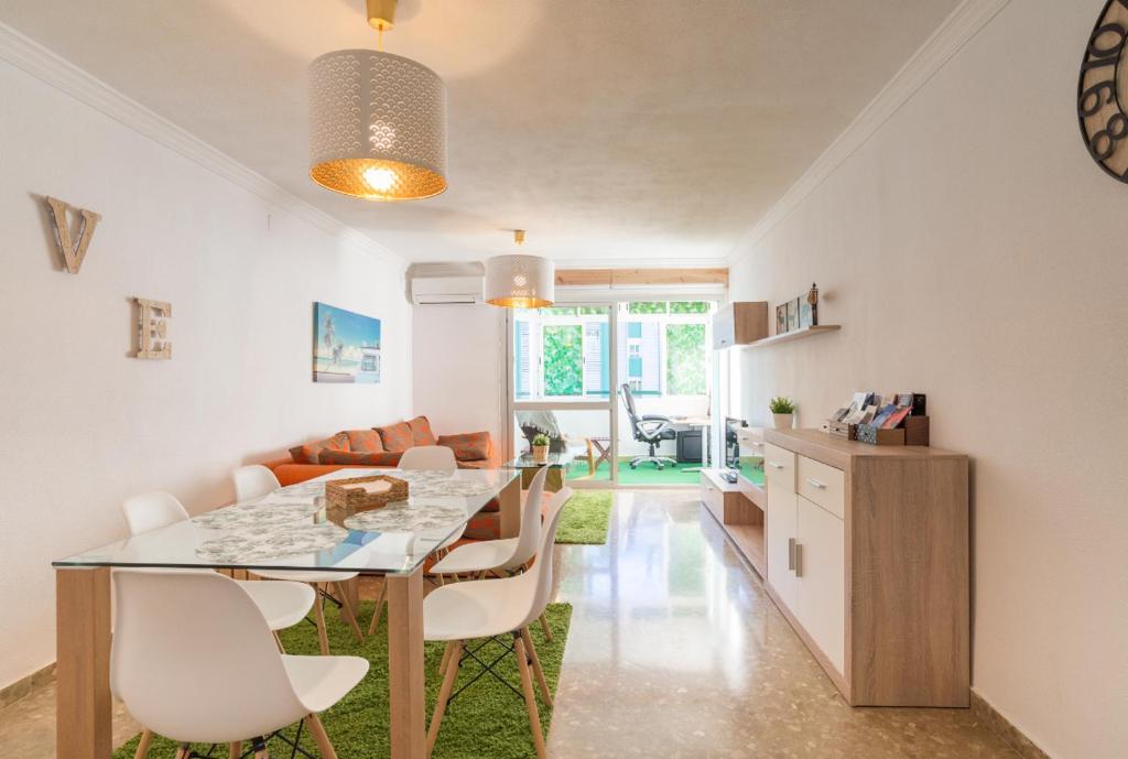 a kitchen and living room with a table and chairs at Sweethome El Palo in Málaga