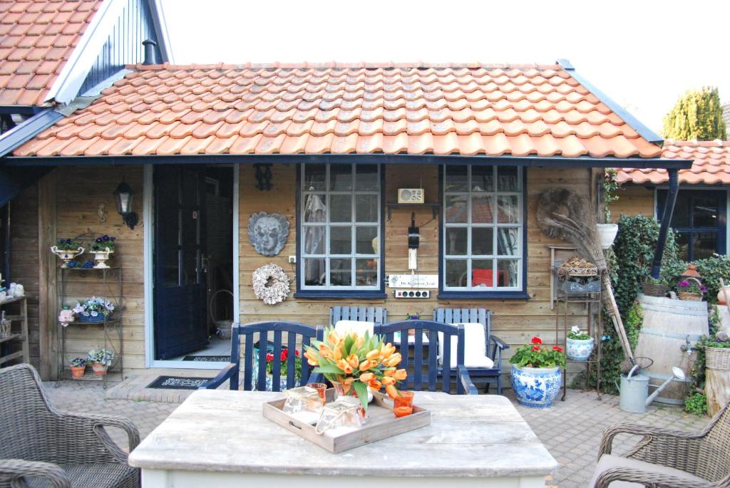 a house with a table and chairs in front of it at Prive tuinhuis B&B Elly in Sint Pancras