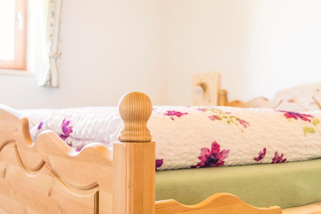 - une planche de pied en bois pour un lit avec une couverture dans l'établissement Tielerhof, à Aldino