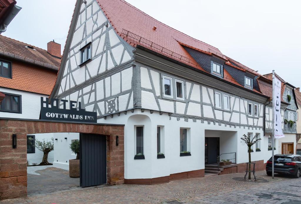 um edifício branco e preto com um telhado vermelho em Gottwalds Inn em Obernburg am Main