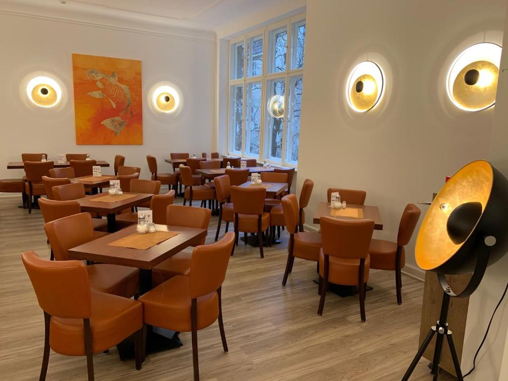 ベルリンにあるホテル サイフェルト ベルリン アム クアフュルステンダムのテーブルと椅子が備わるレストラン