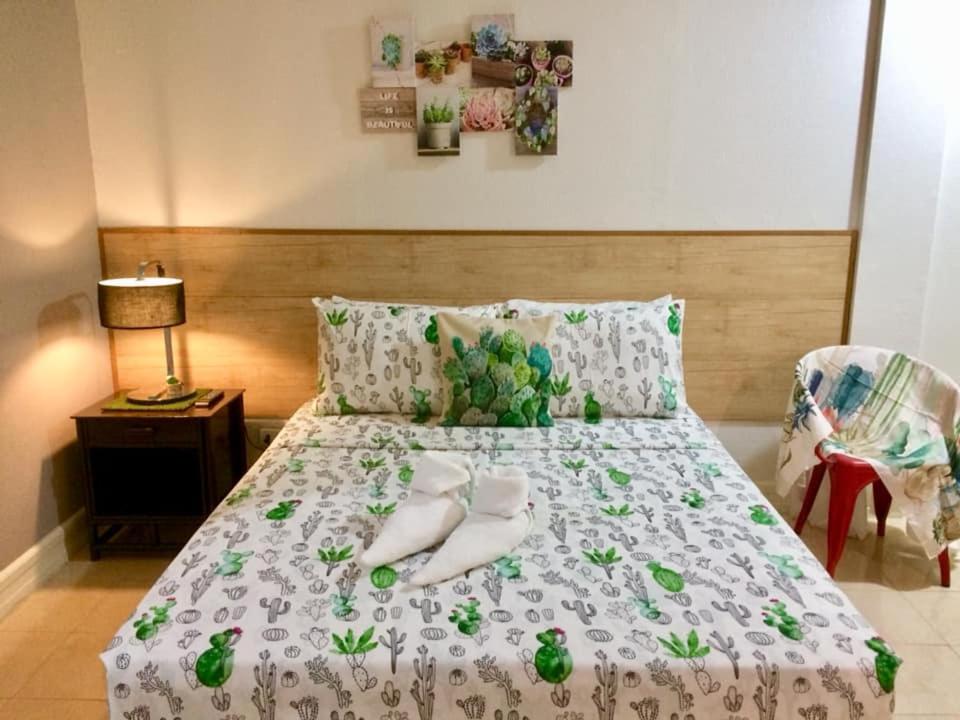 a bedroom with a bed with green flowers on it at VL Garden Suites in Tagbilaran City