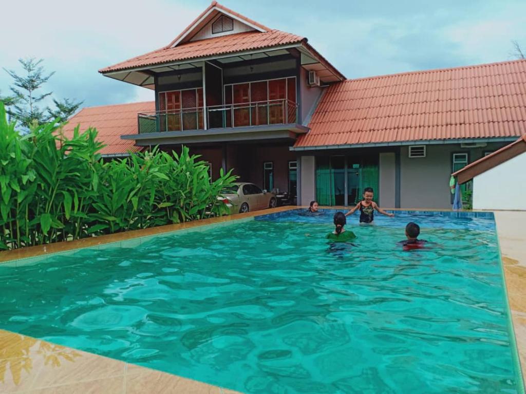 um grupo de crianças na piscina de uma casa em Villa Sri Tebengau em Kuah
