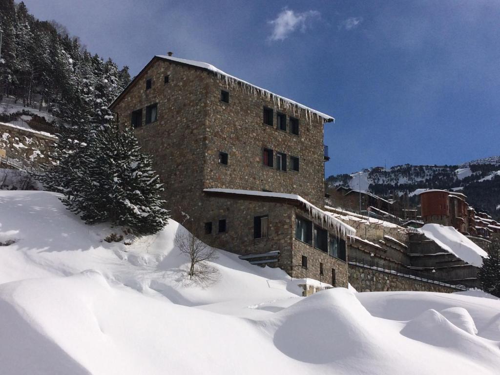 een groot bakstenen gebouw in de sneeuw bij Hotel Roc de St Miquel & Apartment in Soldeu