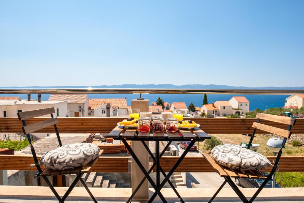 a table with food and drinks on a balcony at Sunrise Apartments Bol in Bol