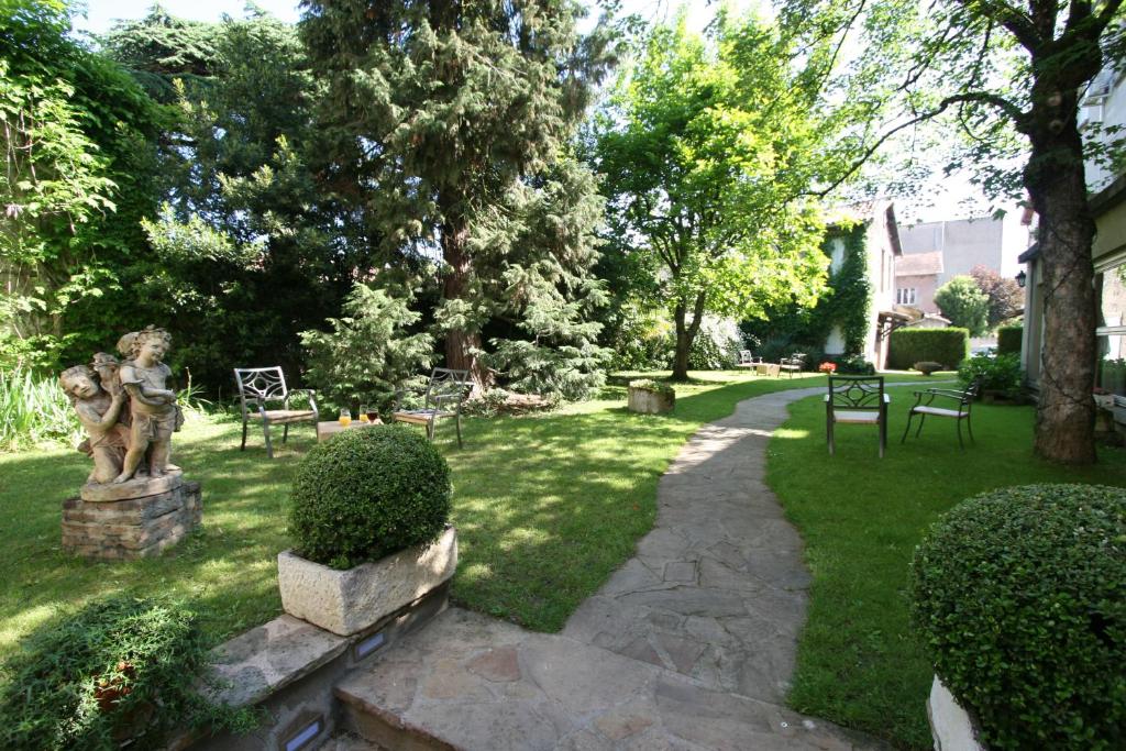 un jardin avec une statue sur l'herbe dans l'établissement Hostellerie Du Grand Saint Antoine, à Albi