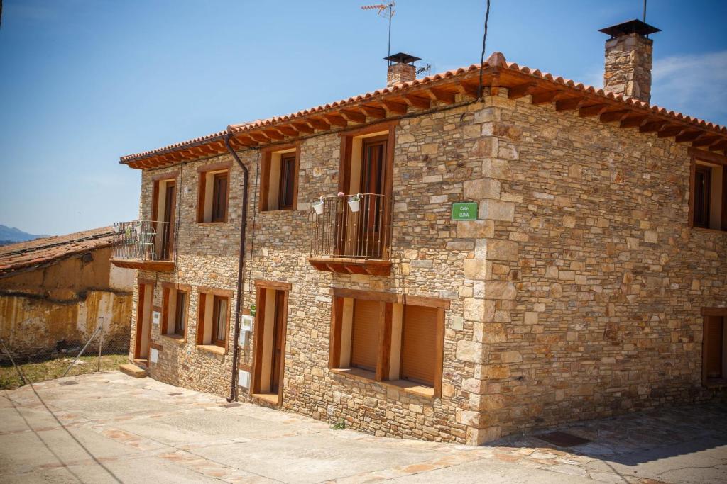 a brick building with a balcony on the side of it at El Bulin de Paredes in Paredes de Buitrago