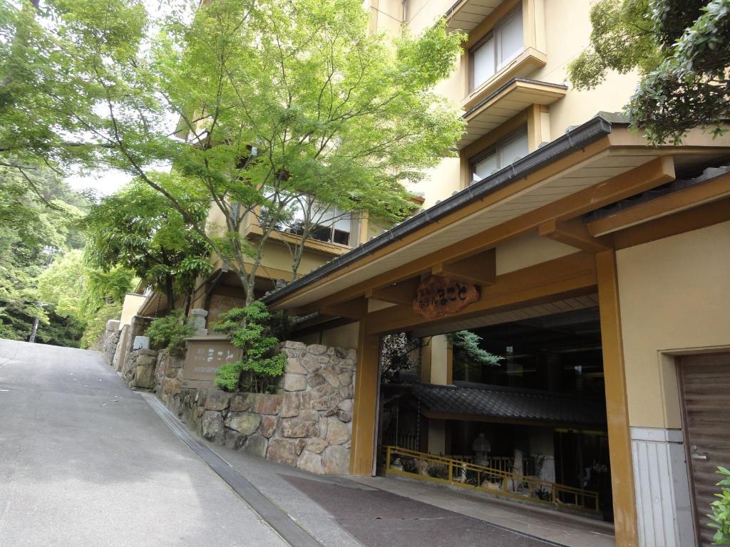 a building with a stone wall next to a street at Miyajima Hotel Makoto in Miyajima
