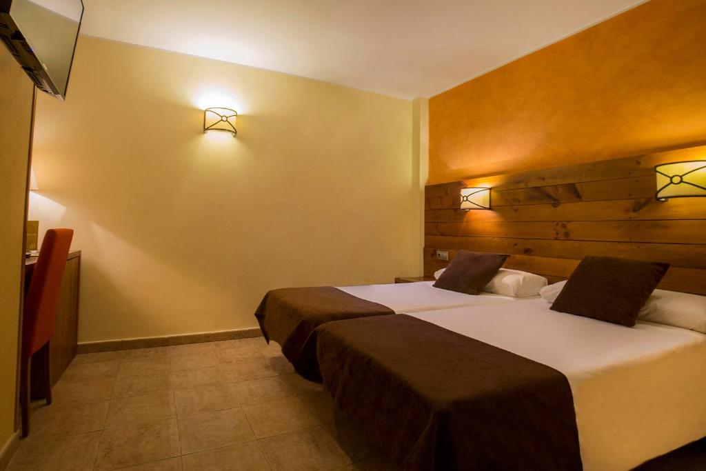 
a hotel room with a bed and two lamps at Magic Pas in Pas de la Casa
