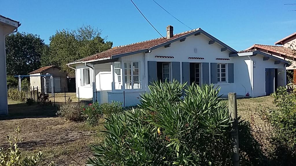 une maison blanche avec une cour dans l'établissement BISCA MAISON FAMILIALE LANDAISE, à Biscarrosse