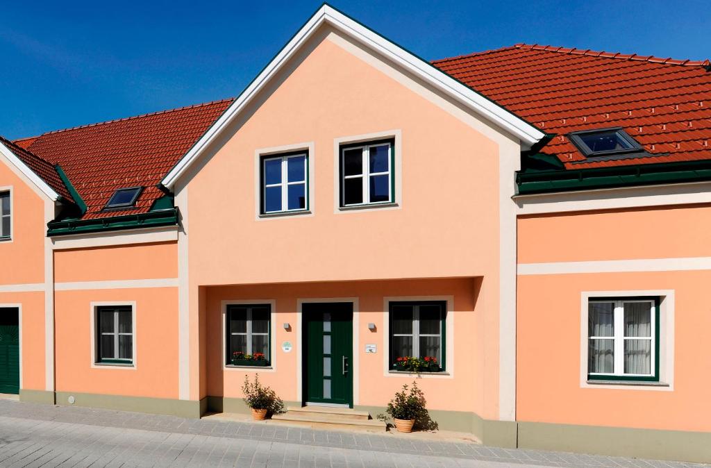 Großriedenthal的住宿－Weingut Familie Schuster，一座大型橙色房子,设有红色屋顶