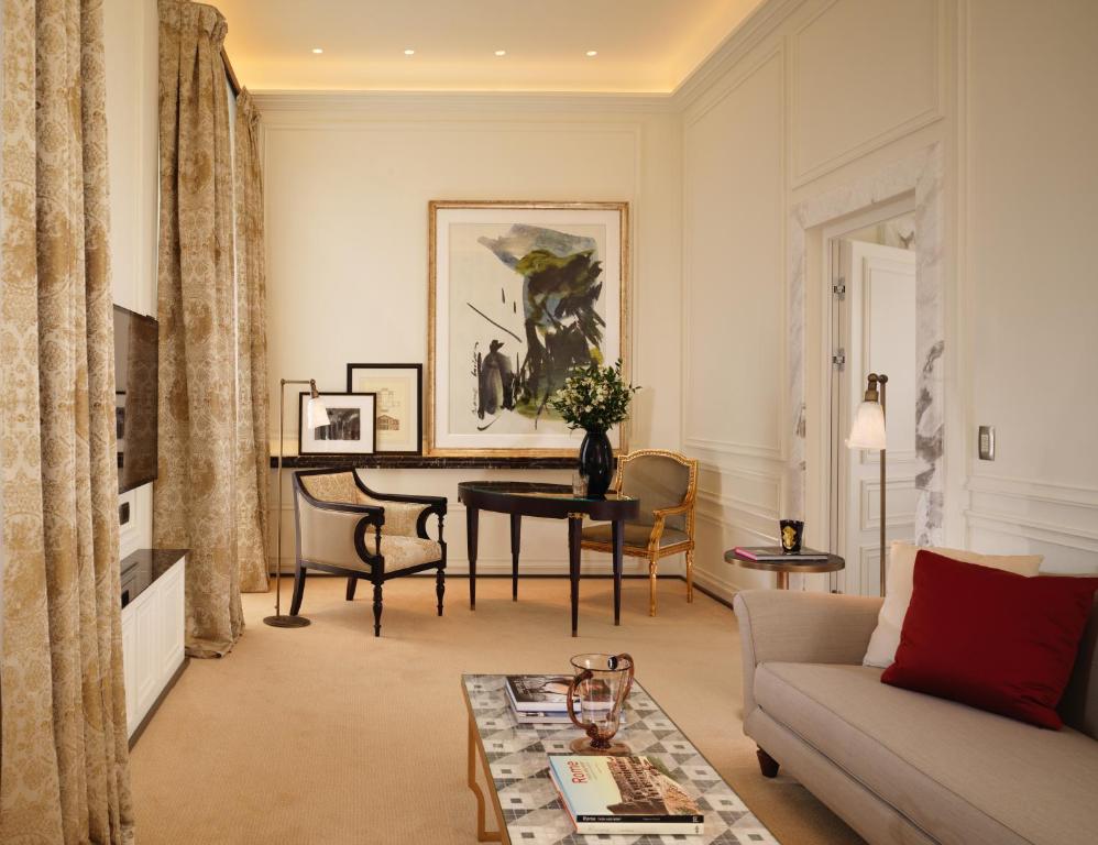 a living room with a couch and a table at Hotel Eden - Dorchester Collection in Rome