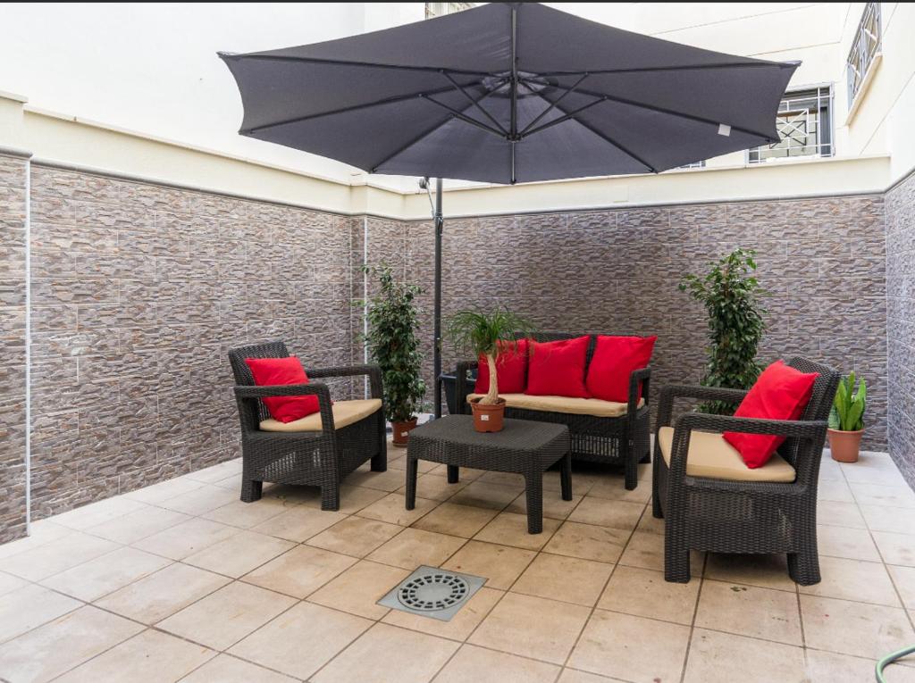 patio z krzesłami, parasolem i stołem w obiekcie MABB-Quiet Apt With Private Patio Walking Distance To Downtown w Maladze