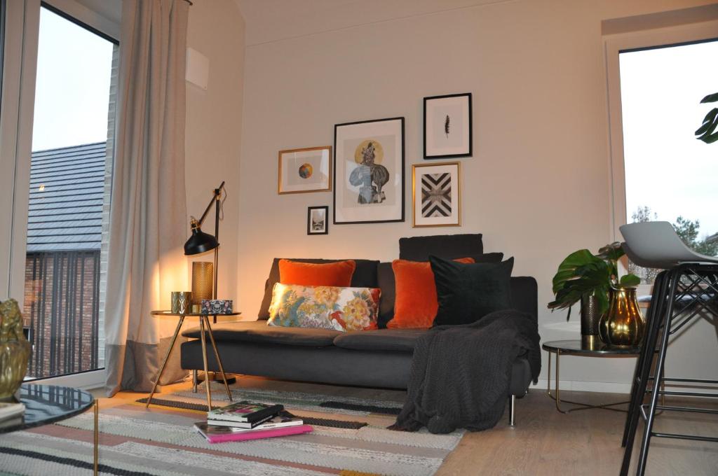 a living room with a black couch and orange pillows at Lieblingsplatz in Rellingen