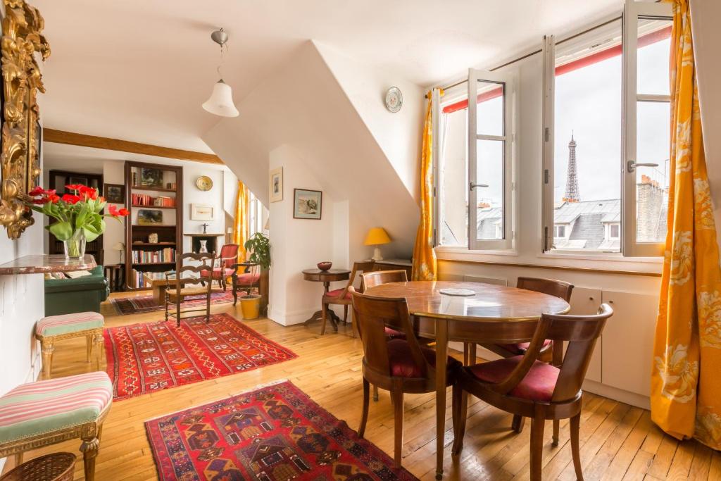 a living room with a wooden table and chairs at Veeve - Views to the Eighth in Paris