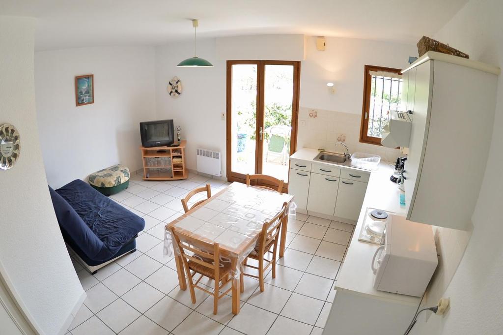 - une cuisine et une salle à manger avec une table et un canapé dans l'établissement Les Coquillages, à Mimizan-Plage
