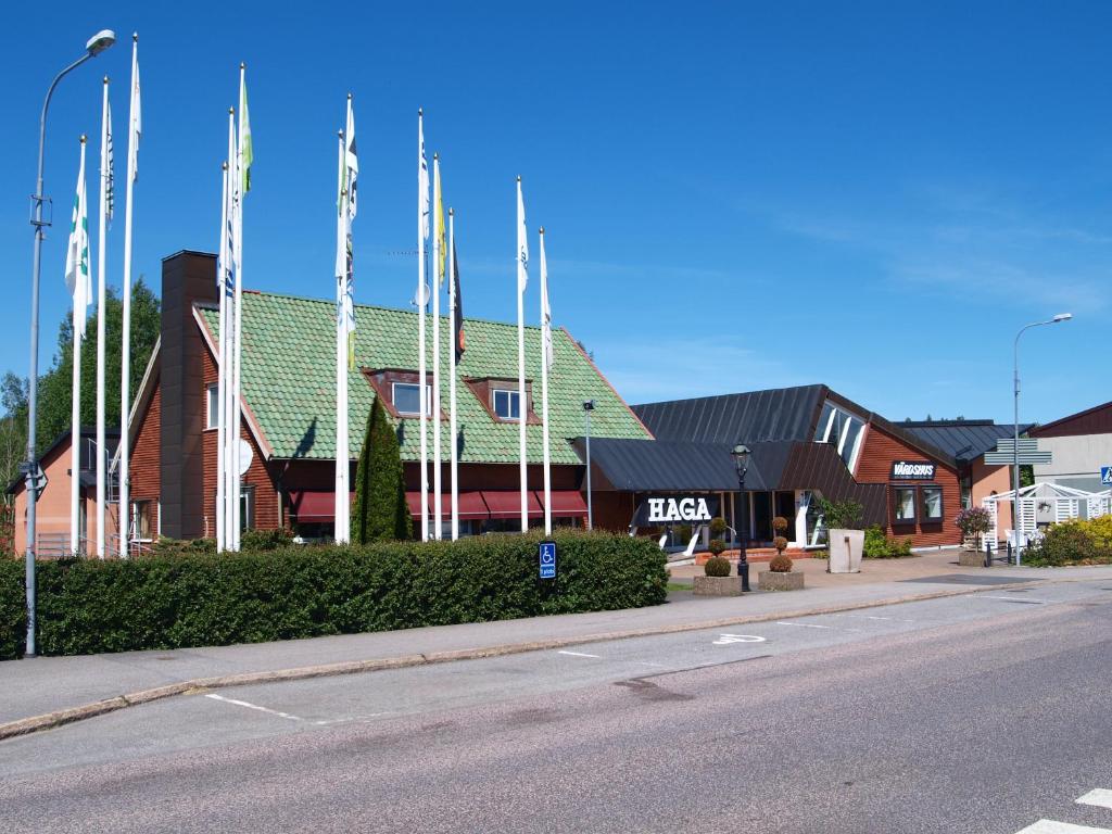 a building with flags on the side of a street at Haga Värdshus in Hillerstorp