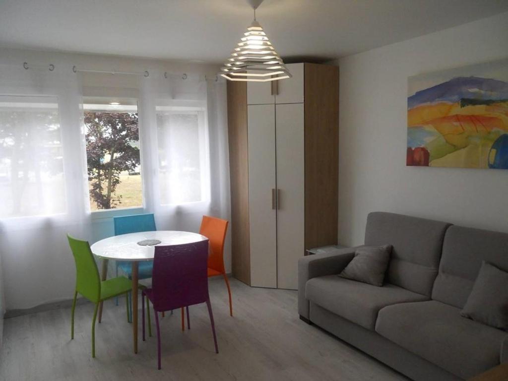 a living room with a couch and a table and chairs at La Forêt 5 in Mimizan-Plage