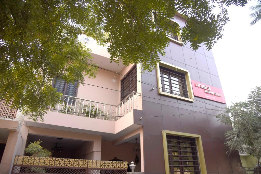 a white building with a balcony in front of it at Udee's Homestay in Agra