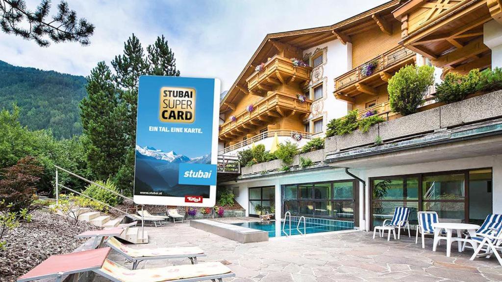 a sign in front of a building with a pool at Hotel Donnerhof in Fulpmes