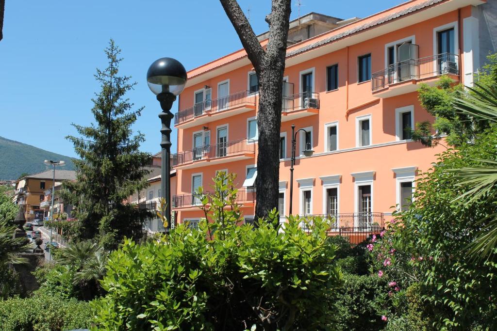 an orange building with a street light and plants at Hotel La Villa in Ceccano