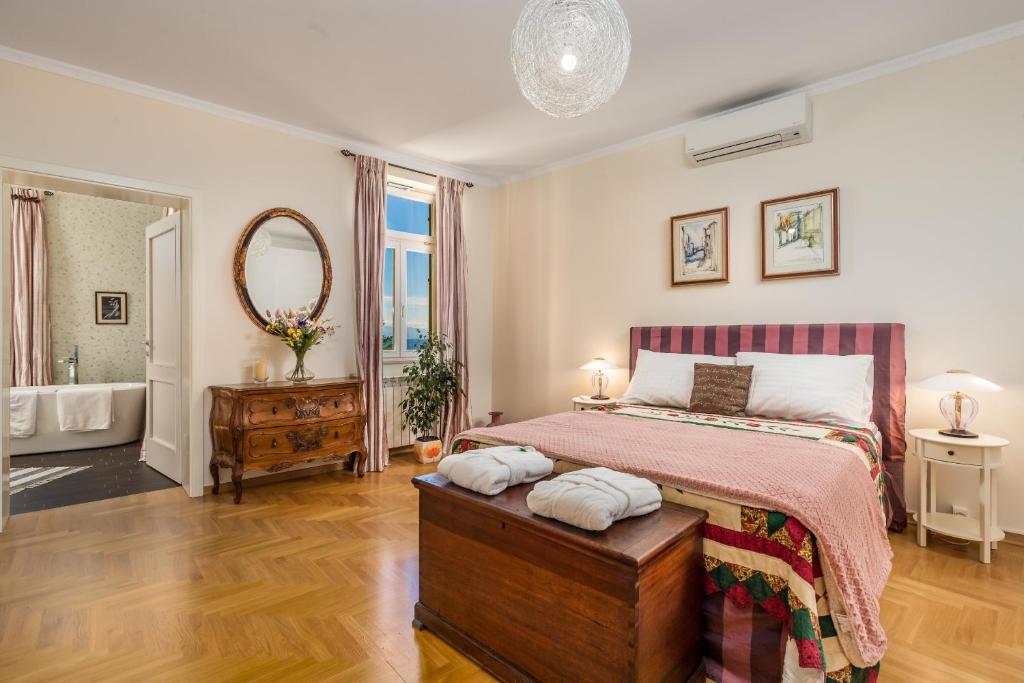 Un dormitorio con una cama y un baño con bañera. en Villa Vilma, en Opatija