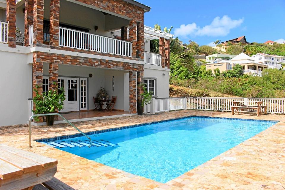 a swimming pool in front of a house at CosyNest in Basseterre