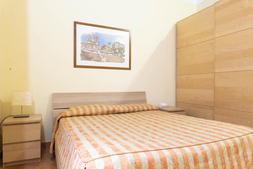 een slaapkamer met een bed en een foto aan de muur bij Sunny Home in Rome