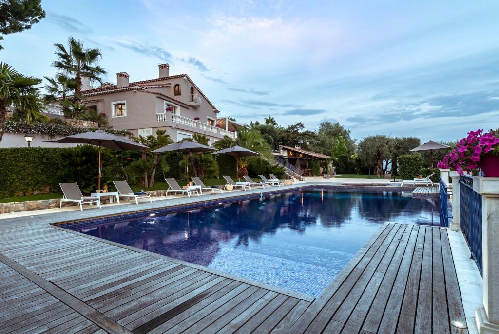 a swimming pool with chairs and a house at TERRE DE REVE in Le Rouret