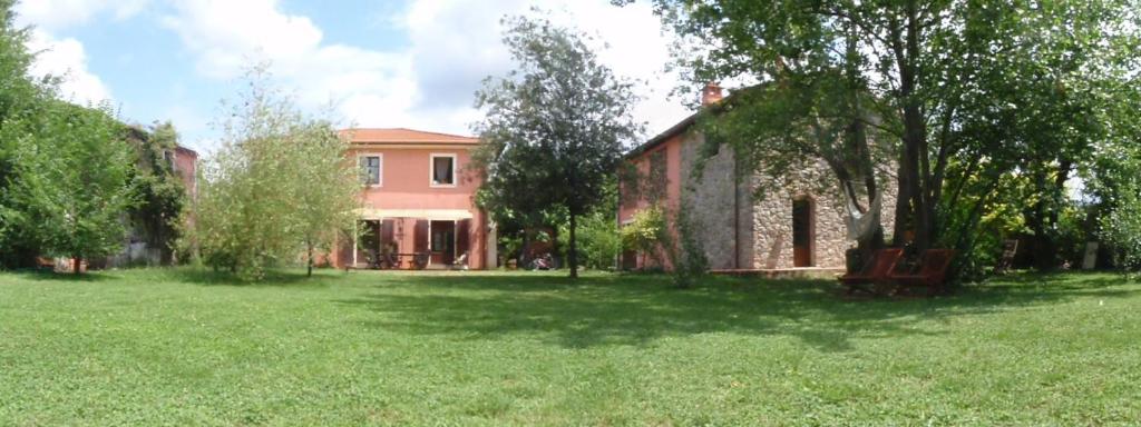uma casa num campo com um quintal com árvores em Rose Cottage Tuscany em Fosdinovo