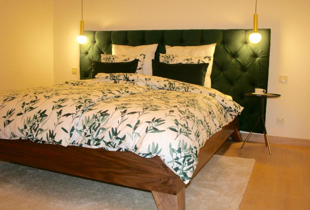 um quarto com uma cama grande e uma cabeceira verde em Elegant apartment em Liepāja