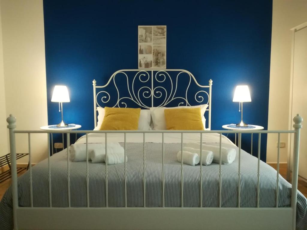 ein blaues Schlafzimmer mit einem Bett mit zwei Lampen in der Unterkunft La Dimora dei sette Arcangeli in Palermo