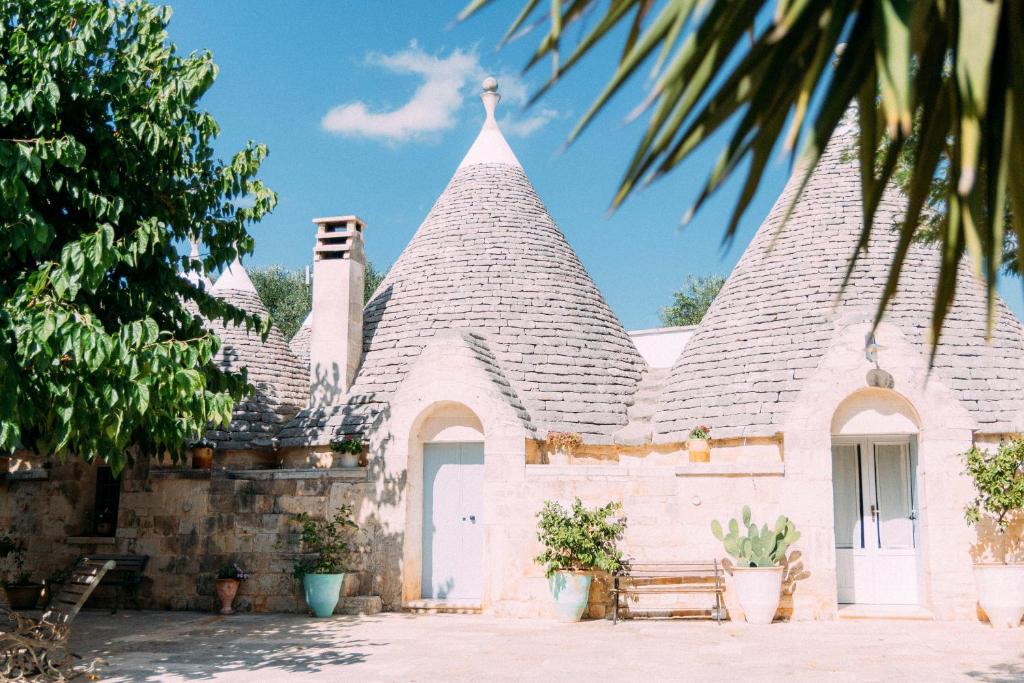 ein weißes Haus mit einem spitzen Dach in der Unterkunft Trullo Santangelo in Ceglie Messapica