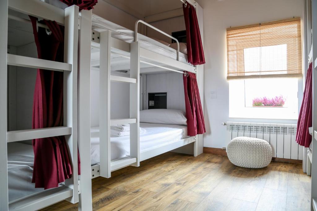 a bedroom with two bunk beds and a window at Bercianos1900 in Bercianos del Real Camino