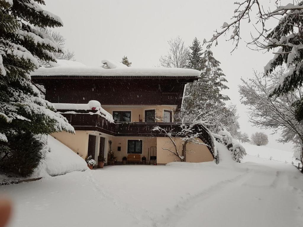 una casa cubierta de nieve con mucha nieve en Gästehaus Wieser, en Haus im Ennstal