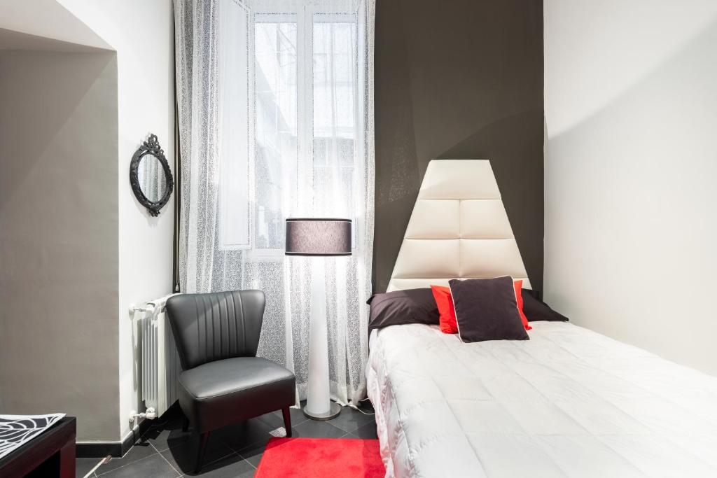 a bedroom with a bed and a chair and a window at Rome in your heart - Spagna Single Room in Rome