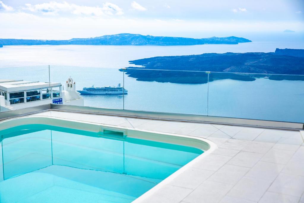 una piscina en una casa con vistas al agua en Pearl on the Cliff Hotel & Suites by Pearl Hotel Collection, en Imerovigli