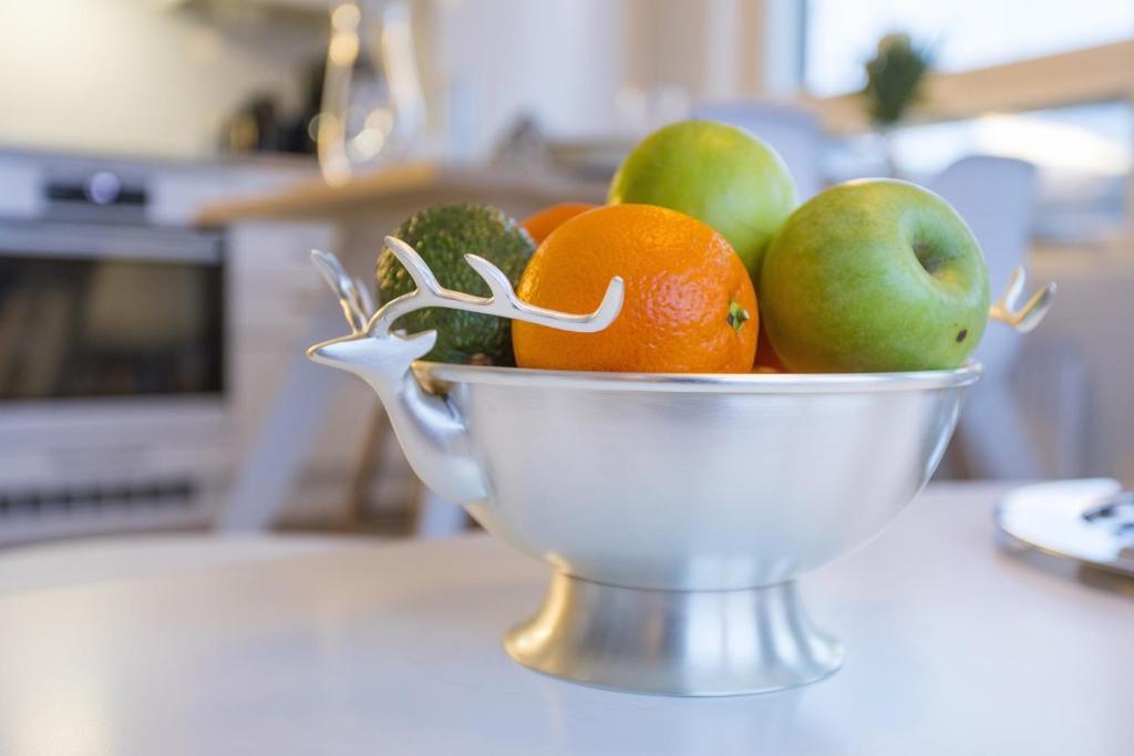 a bowl of fruits and vegetables on a table at Tuomas´ luxurious suites, Ahola in Rovaniemi