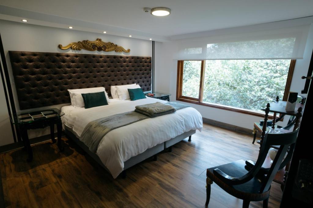 a bedroom with a large bed and a large window at Dolce Lobo Boutique Stay in Quito