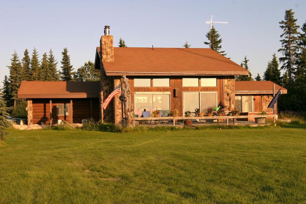 a log house with an american flag on it at Clam Gulch Lodge in Clam Gulch