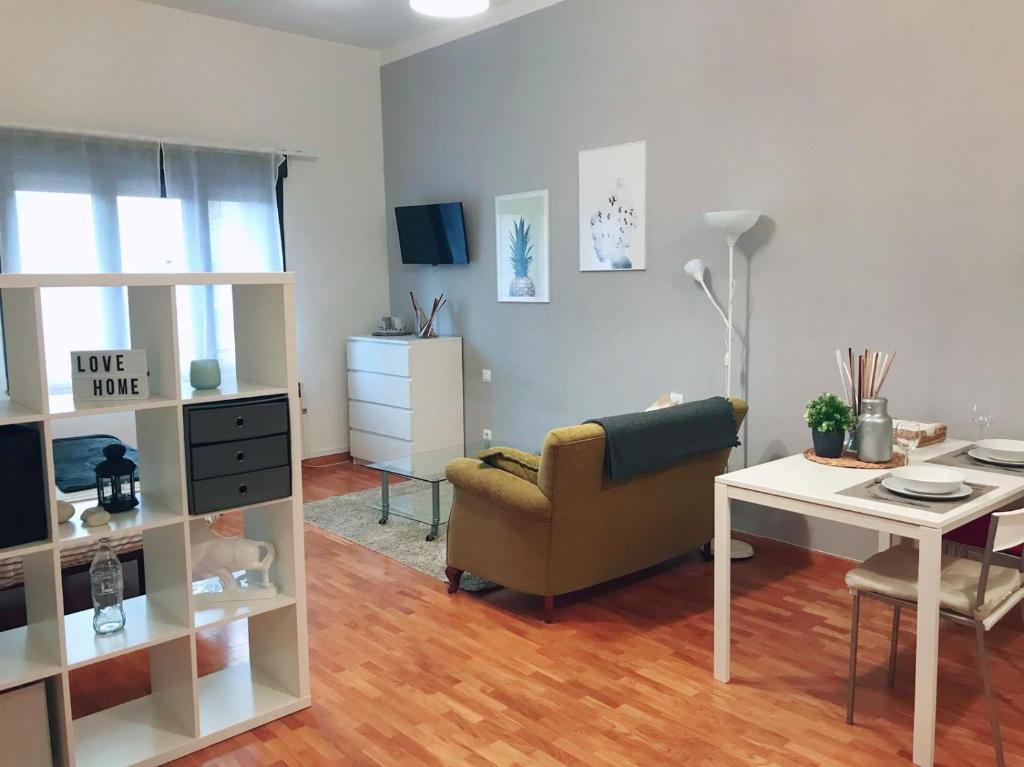 uma sala de estar com um sofá e uma mesa em MONTECERRAO I (GARAJE Y WIFI GRATIS) em Oviedo