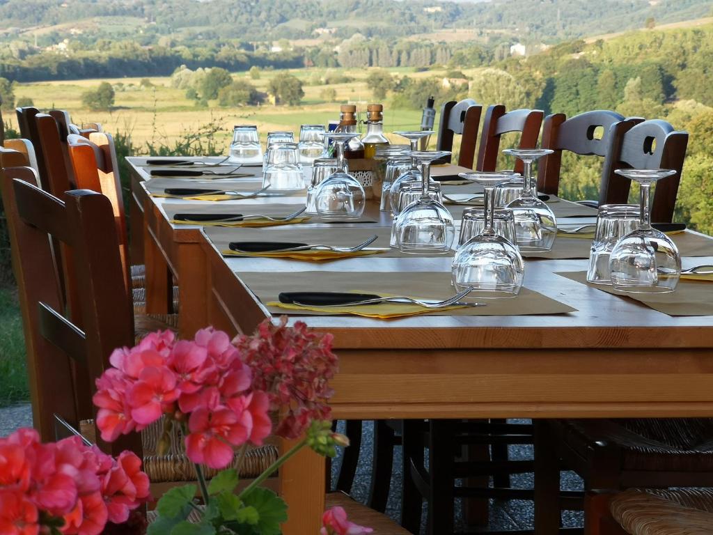 a long table with plates and glasses and flowers at Agriturismo Dimore Di Poggianto in Pergine Valdarno